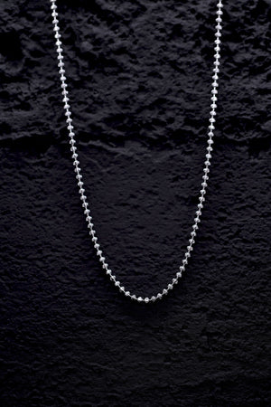 Delicate silver beaded chain necklace on a black background. Shop stylish silver necklaces.