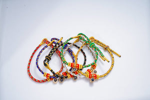 Braided cord bracelets with gold accents and dark beads: red, blue, green, yellow, black.