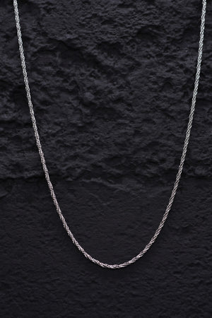 Close-up of a thin, twisted sterling silver rope chain necklace on a black background. Elegant and timeless silver chain for everyday wear.