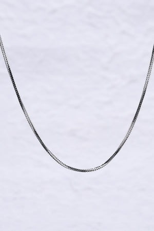 Sleek silver herringbone chain necklace on white background. Minimalist design, perfect for everyday wear.