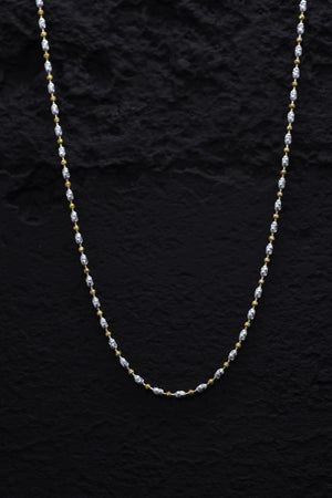 Elegant two-tone sterling silver bead chain necklace closeup on black. Alternating gold & silver oblong links create a minimalist style.