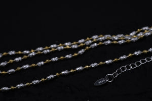 Two-tone gold & silver beaded necklace draped on black, showcasing delicate texture. Sterling silver (S925) detail.