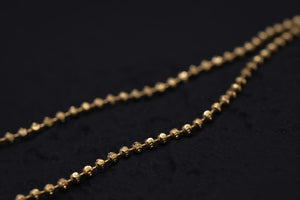 Close-up of a delicate gold beaded chain on black. Elegant simplicity perfect for Tibetan dzi beads or a mala.