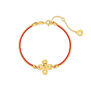 Gold-plated Tibetan knot bracelet on red string. Close-up on white background. Elegant, auspicious symbol of protection and harmony.