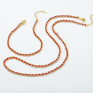 Elegant gold chain necklace intertwined with red thread. Features a heart charm and lobster clasp. Tibetan Buddhist prayer beads style.