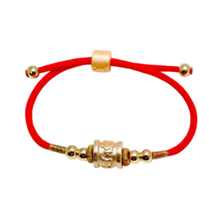 Red string Tibetan prayer bead bracelet with gold Om Mani Padme Hum mantra beads and clasp on white background.