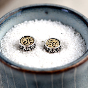Elegant silver & brass Om stud earrings with heart details. Tibetan Buddhist prayer jewelry for mindful style.