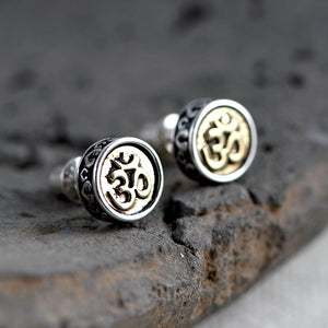 Elegant Om stud earrings with textured silver border and gold Om symbol. Tibetan Buddhist prayer jewelry for mindful style.