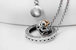 Intricate silver necklace with patterned circular pendant, textured dzi bead, and S925 stamp. Tibetan dzi beads jewelry.