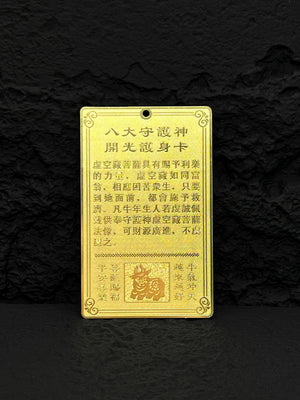 Gold amulet card with Chinese characters for wealth and protection, especially for those born in the Year of the Ox. Features Ox image on textured black background. Fengshui 2024 amulet.