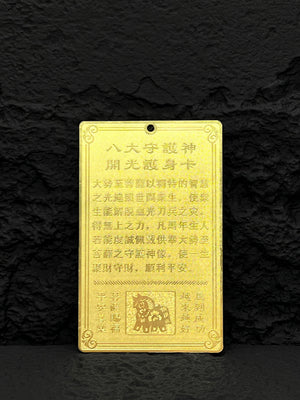 Gold amulet with Chinese text referencing the Eight Great Guardian Deities and protection, featuring a stylized horse on a black background. Amulet for protection.