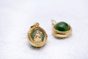 Two gold pendants: oval pendant with deity figurine in green setting, and jade pendant with gold setting marked '925'.