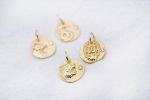 Gold pendants featuring dragon, lion, wolf, and fish designs with diamond accents. Mythological creature pendant set.