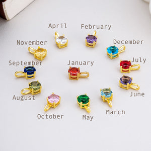 Gemstone pendants representing each birth month in a circular arrangement. Gold-plated settings showcase colorful stones for January to December.