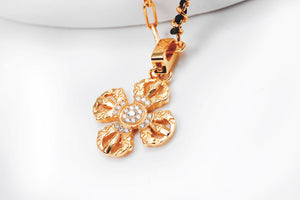 Gold diamond-studded Vajra pendant on a chain. Intricate Tibetan Buddhist symbol in a clean, close-up studio shot.