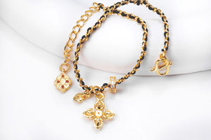 Gold Vajra bracelet on black cord with delicate floral accents and sparkling gems. Tibetan Buddhist symbol for protection and enlightenment.