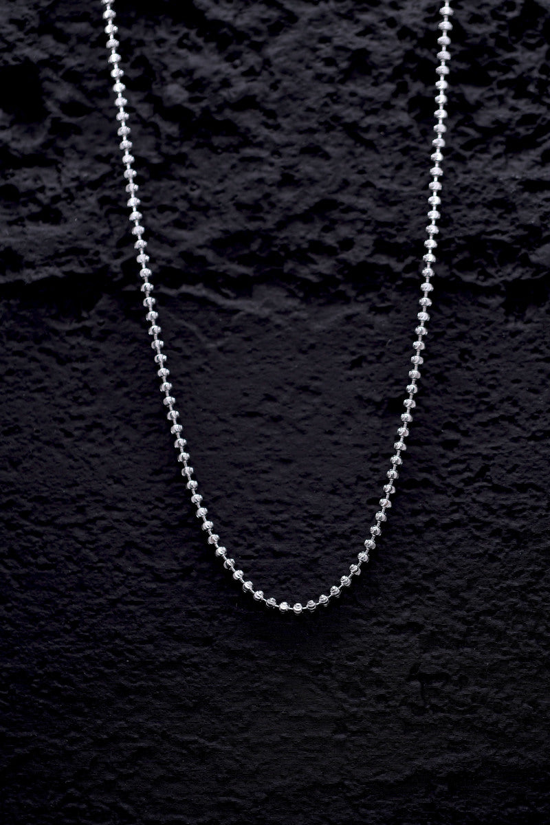 Delicate silver beaded chain necklace on a black background. Shop stylish silver necklaces.