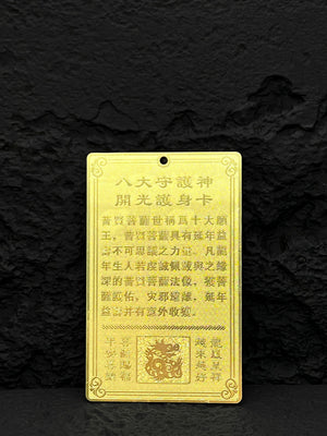 Gold Buddhist amulet with Chinese characters and dragon detail on black background. Evokes traditional spirituality and protection. Buddhist amulet necklace.