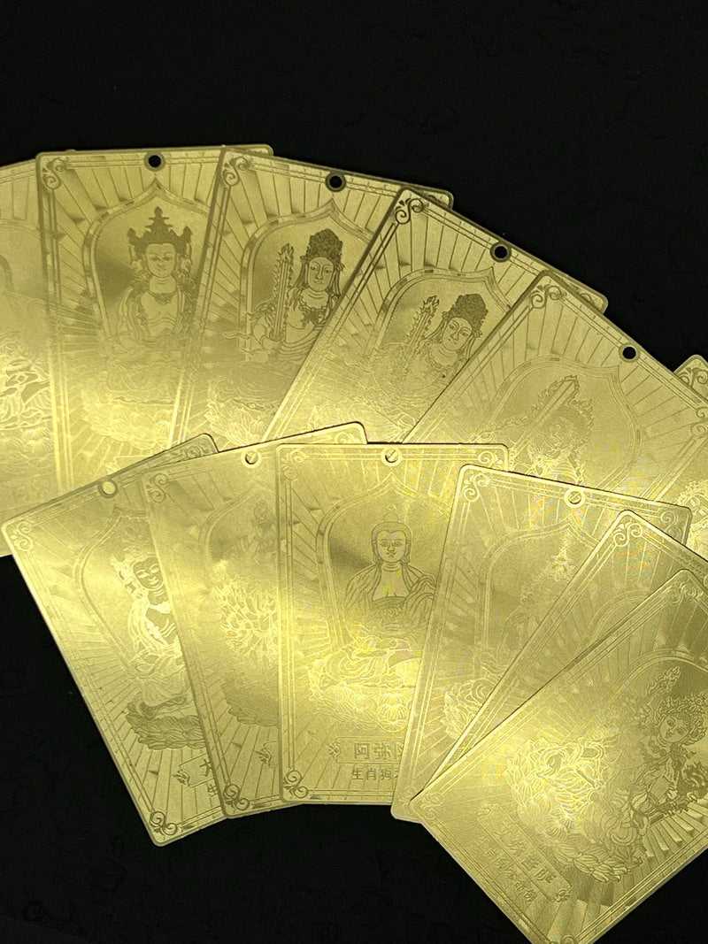 Close-up of gold Tibetan plaques with etched Buddhist deities, lotus flowers, and Chinese characters. Ideal for thangka art enthusiasts.