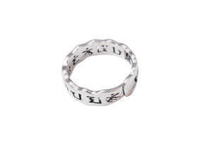 Close-up of a Tibetan silver ring with Om Mani Padme Hum mantra engraved on a unique, wavy band. Minimalist style, perfect for meditation and balance.