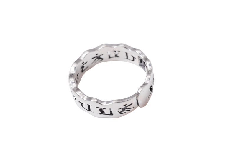 Close-up of a Tibetan silver ring with Om Mani Padme Hum mantra engraved on a unique, wavy band. Minimalist style, perfect for meditation and balance.