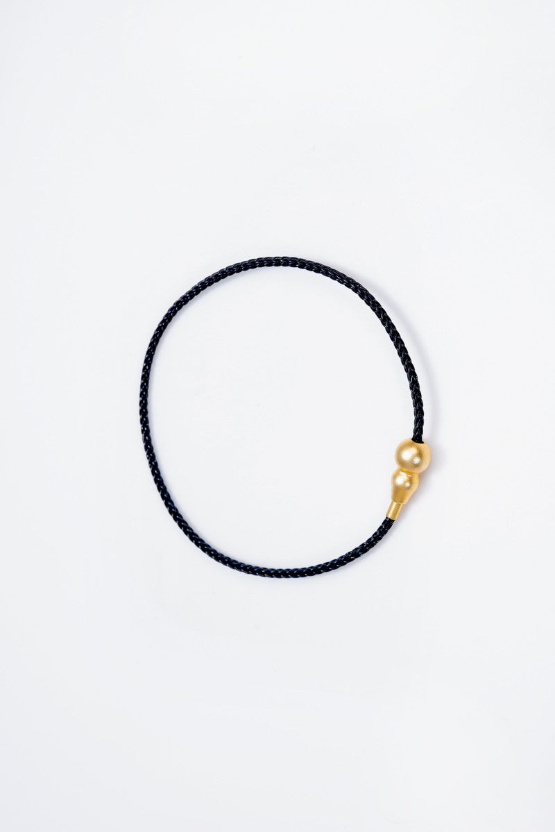 Elegant black braided cord bracelet with gold double-bead accent. Minimalist style, perfect for everyday wear. Buddhist prayer beads.