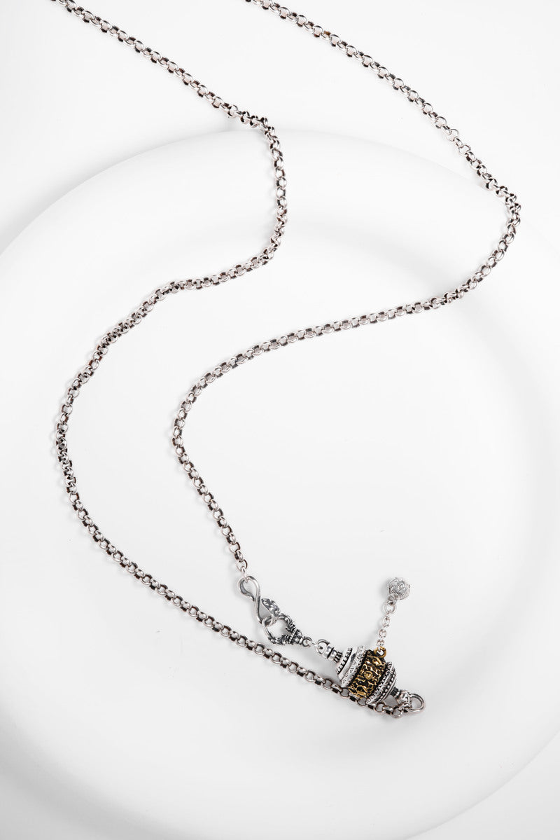 Elegant silver necklace with two-tone prayer wheel pendant. Tibetan dzi beads inspire this minimalist, spiritual jewelry piece.