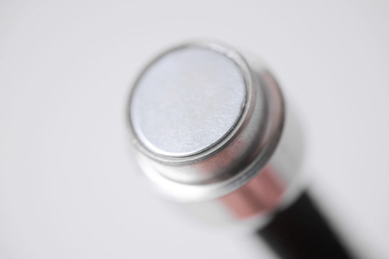 Close-up of a rose gold and silver amulet necklace on a white background. Tibetan amulet for protection.