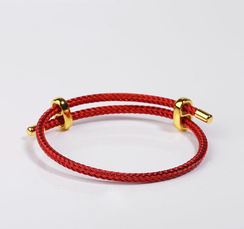 Red braided bracelet with gold accents. Stylish and durable wrist accessory.